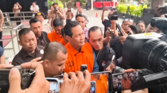Bupati Muara Enim Edison (tengah) berjalan usai menjalani pemeriksaan di gedung KPK Merah Putih, Jakarta, Rabu (9/6/2026). [Suara.com/Alfian Winanto] 