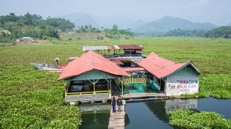 Dua orang anak melintasi jembatan di atas aliran sungai Citarum yang dipenuhi eceng gondok di Cililin, Kabupaten Bandung Barat, Jawa Barat, Kamis (11/6/2026). [ANTARA FOTO/Abdan Syakura/foc]