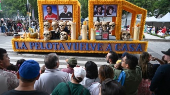 Sejumlah warga menyaksikan foto-foto mendiang pesepak bola legendaris diarak dalam Gran Desfile Mundialista atau Parade Akbar Piala Dunia 2026 di Paseo de la Reforma, Mexico City, Meksiko, Sabtu (13/6/2026) waktu setempat. [ANTARA FOTO/Aditya Pradana Putra/kye]
