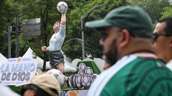 Sejumlah warga menyaksikan repilka patung adegan Gol Tangan Tuhan Maradona dalam Gran Desfile Mundialista atau Parade Akbar Piala Dunia 2026 di Paseo de la Reforma, Mexico City, Meksiko, Sabtu (13/6/2026) waktu setempat. [ANTARA FOTO/Aditya Pradana Putra/kye]
