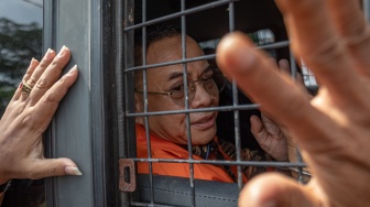 Bupati Pati nonaktif Sudewo menyapa pendukungnya dari dalam mobil tahanan seusai menjalani sidang perdana pembacaan dakwaan di Pengadilan Tipikor Semarang, Jawa Tengah, Senin (15/6/2026). [ANTARA FOTO/Aji Styawan/nym]