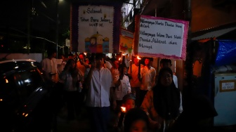 Sejumlah warga dan anak-anak mengikuti pawai obor di Kawasan Menteng, Jakarta Pusat, Senin (15/6/2026).  [Suara.com/Alfian Winanto]