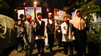 Sejumlah warga dan anak-anak mengikuti pawai obor di Kawasan Menteng, Jakarta Pusat, Senin (15/6/2026).  [Suara.com/Alfian Winanto]