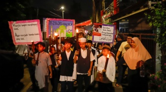Sejumlah warga dan anak-anak mengikuti pawai obor di Kawasan Menteng, Jakarta Pusat, Senin (15/6/2026).  [Suara.com/Alfian Winanto]