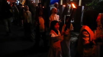 Sejumlah warga dan anak-anak mengikuti pawai obor di Kawasan Menteng, Jakarta Pusat, Senin (15/6/2026).  [Suara.com/Alfian Winanto]