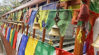 Deretan lonceng kuningan dan bendera doa khas Tibet menghiasi salah satu sudut tempat suci di jalur pendakian menuju kawasan Himalaya, Nepal, Selasa (26/5/2026). [Suara.com/Rizka Chaerani]