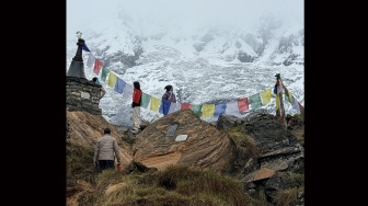 Pendaki melintasi batu prasasti dan stupa peringatan bagi para pendaki yang gugur di kawasan Annapurna Base Camp, Nepal, Rabu (27/5/2026). [Suara.com/Rizka Chaerani]
