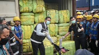 Menteri Keuangan Purbaya Yudhi Sadewa (kiri) dan Dirjen Bea dan Cukai Djaka Budhi Utama (kanan) menunjukkan pakaian bekas impor ilegal (balpres) saat konferensi pers penindakan peti kemas pakaian bekas ilegal di Buffer Area TPS CDC Pelabuhan Tanjung Priok, Jakarta, Selasa (23/6/2026). [ANTARA FOTO/Sulthony Hasanuddin/tom]