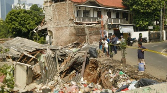 Warga melihat kondisi bangunan yang terdampak tanah longsor di Petamburan, Tanah Abang, Jakarta, Jumat (26/6/2026). [Suara.com/Alfian Winanto]
