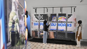 Pengunjung melihat karya foto saat pameran foto bertajuk Perisai Tunas di ANTARA Heritage Center, Jakarta, Kamis (25/6/2026). [Suara.com/Alfian Winanto]