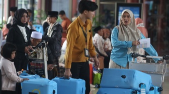 Petugas menata koper bawaan jamaah calon umrah di Terminal 2 F Khusus Umrah dan Haji Bandara Soekarno-Hatta, Tangerang, Banten, Rabu (1/7/2026). [ANTARA FOTO/Muhammad Iqbal/tom]