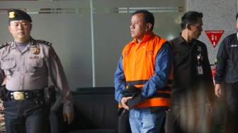 Bupati Kuantan Singingi Suhardiman Amby (tengah) berjalan menuju mobil tahanan usai menjalani pemeriksaan di Gedung Merah Putih KPK, Jakarta, Rabu (1/7/2026). [Suara.com/Alfian Winanto]
