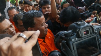 Bupati Kuantan Singingi Suhardiman Amby (tengah) berjalan menuju mobil tahanan usai menjalani pemeriksaan di Gedung Merah Putih KPK, Jakarta, Rabu (1/7/2026). [Suara.com/Alfian Winanto]
