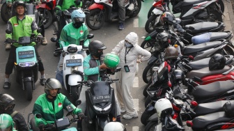 Pengemudi ojek online menjemput penumpang di seberang Stasiun Palmerah, Jakarta, Kamis (2/7/2026). [Suara.com/Alfian Winanto]