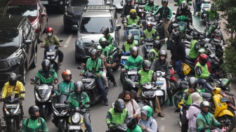 Pengemudi ojek online menjemput penumpang di seberang Stasiun Palmerah, Jakarta, Kamis (2/7/2026). [Suara.com/Alfian Winanto]