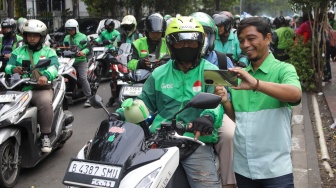 Pengemudi ojek online menjemput penumpang di seberang Stasiun Palmerah, Jakarta, Kamis (2/7/2026). [Suara.com/Alfian Winanto]