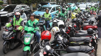 Pengemudi ojek online menjemput penumpang di seberang Stasiun Palmerah, Jakarta, Kamis (2/7/2026). [Suara.com/Alfian Winanto]