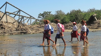 Sejumlah pelajar menyeberang sungai akibat putusnya jembatan Termanu di Kecamatan Amfoang, Kabupaten Kupang, Nusa Tenggara Timur, Selasa (7/7/2026). [ANTARA FOTO/Kornelis Kaha/sgd]