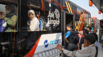 Warga antre menaiki bus Transjakarta di Terminal Blok M, Jakarta, Kamis (9/7/2026). [Suara.com/Alfian Winanto]