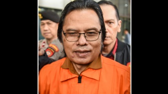 Tersangka kasus dugaan gratifikasi dalam pengadaan barang dan jasa Ma'ruf Cahyono (tengah) mengenakan rompi tahanan usai menjalani pemeriksaan di Gedung Merah Putih KPK, Jakarta, Kamis (9/7/2026). [ANTARA FOTO/Reno Esnir/sth/foc]