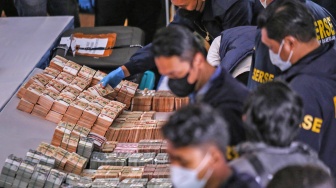KPetugas merapihkan barang bukti sejumlah uang usai ditampilkan pada konferensi pers di Polda Metro Jaya, Jakarta, Jumat (10/7/2026). [ANTARA FOTO/Asprilla Dwi Adha/foc]