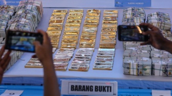 Wartawan memfoto barang bukti emas dan sejumlah uang saat ditampilkan pada konferensi pers di Polda Metro Jaya, Jakarta, Jumat (10/7/2026). [ANTARA FOTO/Asprilla Dwi Adha/foc]