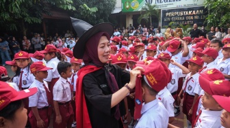Seorang guru mengenakan kostum bertema serial novel Harry Potter sambil membetulkan topi siswa baru saat pembukaan Masa Pengenalan Lingkungan Sekolah (MPLS) di SD Negeri Cemara 2 Solo, Jawa Tengah, Senin (13/7/2026). [ANTARA FOTO/Maulana Surya/tom]