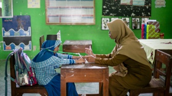 Seorang guru mengajar satu siswa baru saat Masa Pengenalan Lingkungan Sekolah (MPLS) di SD Negeri Cepokosawit II, Boyolali, Jawa Tengah, Senin (13/7/2026). [ANTARA FOTO/Mohammad Ayudha/tom]
