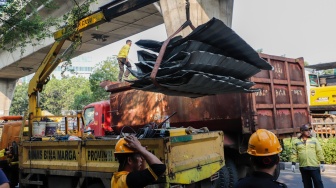 Petugas membongkar Jembatan Penyeberangan Orang (JPO) Tendean yang rusak usai tertabrak truk pengangkut alat berat di kawasan Tendean, Jakarta, Selasa (14/7/2026). [Suara.com/Alfian Winanto]