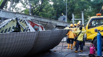 Petugas membongkar Jembatan Penyeberangan Orang (JPO) Tendean yang rusak usai tertabrak truk pengangkut alat berat di kawasan Tendean, Jakarta, Selasa (14/7/2026). [Suara.com/Alfian Winanto]