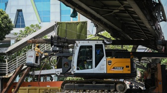 Petugas melakukan proses evakuasi truk bermuatan alat berat yang menabrak jembatan penyeberangan orang (JPO) di Jalan Kapten Tendean, Jakarta, Selasa (14/7/2026). [ANTARA FOTO/Fauzan/nym]