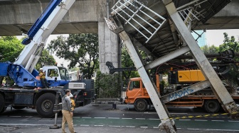 Petugas melakukan proses evakuasi truk bermuatan alat berat yang menabrak jembatan penyeberangan orang (JPO) di Jalan Kapten Tendean, Jakarta, Selasa (14/7/2026). [ANTARA FOTO/Fauzan/nym]