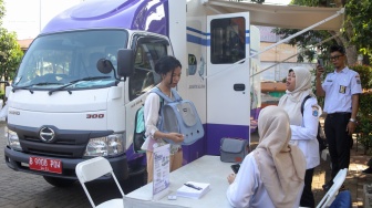 Warga membawa hewan peliharaannya untuk diperiksa di mobil Klinik Hewan Keliling Jakarta, di Jakarta, Rabu (15/7/2026). [Suara.com/Alfian Winanto]