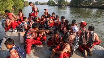 Sejumlah siswa SDN 02 Desa Pantai Bahagia berada di atas perahu melintasi Sungai Citarum saat berangkat ke sekolah di Muara Gembong, Kabupaten Bekasi, Jawa Barat, Kamis (16/7/2026). [ANTARA FOTO/Darryl Ramadhan/YU]
