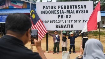 Sejumlah warga Nunukan berfoto di depan patok dua perbatasan Indonesia-Malaysia di Desa Aji Kuning, Kecamatan Sebatik Tengah, Kabupaten Nunukan, Kalimantan Utara, Minggu (19/7/2026). [ANTARA FOTO/M Risyal Hidayat/wsj]