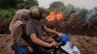 Pengendara melintas di dekat lokasi kebakaran hutan dan lahan (karhutla) di kawasan lahan gambut Desa Cot Seumeureng, Kecamatan Samatiga, Aceh Barat, Aceh, Minggu (19/7/2026). [ANTARA FOTO/Syifa Yulinnas/wsj]