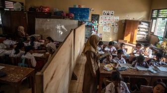 Sejumlah siswa kelas 3 dan 4 mengikuti kegiatan belajar mengajar di ruang kelas yang disekat akibat bangunan kelas ambruk di SD Negeri Tanggirejo, Tegowanu, Grobogan, Jawa Tengah, Selasa (21/7/2026). [ANTARA FOTO/Aprillio Akbar/YU]