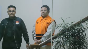 Bupati Lombok Barat Lalu Ahmad Zaini berjalan menuju mobil tahanan usai menjalani pemeriksaan di Gedung Merah Putih KPK, Jakarta, Selasa (21/7/2026). [Suara.com/Alfian Winanto]