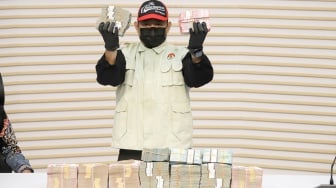 Petugas menunjukan barang bukti berupa uang tunai hasil dari Operasi Tangkap Tangan (OTT) Bupati Lombok Barat Lalu Ahmad Zaini saat konferensi pers di Gedung Merah Putih KPK, Jakarta, Selasa (21/7/2026). [Suara.com/Alfian Winanto]