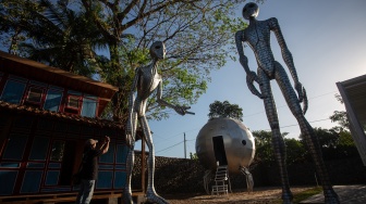 Pengunjung memotret karya yang dipamerkan saat Cosmos Exhibition di Kampung Alien, Nanggulan, Kulon Progo, D.I Yogyakarta, Selasa (21/7/2026). [ANTARA FOTO/Andreas Fitri Atmoko/sgd]