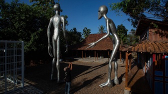 Pengunjung memotret karya yang dipamerkan saat Cosmos Exhibition di Kampung Alien, Nanggulan, Kulon Progo, D.I Yogyakarta, Selasa (21/7/2026). [ANTARA FOTO/Andreas Fitri Atmoko/sgd]