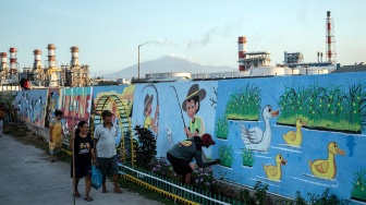 Warga menyelesaikan pembuatan mural bertema lingkungan di tanggul pengaman pantai Kampung Bahari Tambaklorok, Semarang, Jawa Tengah, Kamis (23/7/2026). [ANTARA FOTO/Aprillio Akbar/foc]