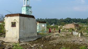 Warga berjalan melintas di sekitar puing-puing bangunan rumah yang kembali muncul di kawasan Bendungan Karian yang mengering di Kampung Somang, Lebak, Banten, Jumat (24/7/2026). [ANTARA FOTO/Muhammad Bagus Khoirunas/YU]