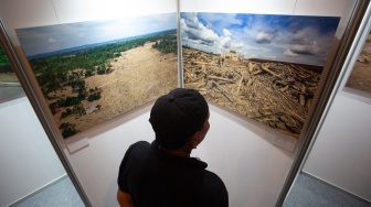 Pengunjung mengamati pameran foto saat peluncuran buku foto Prahara Pulau Emas di Omah Petroek, Pakem, Sleman, D.I Yogyakarta, Sabtu (25/7/2026). [ANTARA FOTO/Andreas Fitri Atmoko/nym]