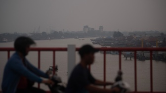 Pengendara motor melintasi Jembatan Musi VI dengan latar Sungai Musi yang diselimuti kabut asap di Palembang, Sumatera Selatan, Rabu (5/8/2026). [ANTARA FOTO/Nova Wahyudi/foc]