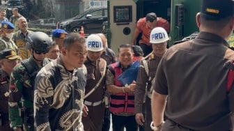 Senyum Tipis Febrie Adriansyah Saat Tiba di Kejagung, Tangan Terborgol dan Pakai Rompi Pink