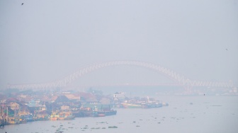 Sejumlah kapal melintas di perairan sungai musi yang diselimuti kabut asap di Palembang, Sumatera Selatan, Kamis (13/8/2026). [ANTARA FOTO/Nova Wahyudi/YU]