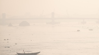 Sejumlah kapal tradisional melintas di perairan sungai musi yang diselimuti kabut asap di Palembang, Sumatera Selatan, Kamis (13/8/2026). [ANTARA FOTO/Nova Wahyudi/YU]