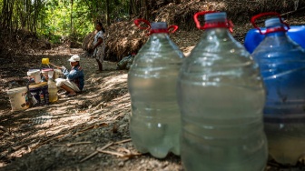 Warga mengambil air dari belik yang dibuat di dasar sungai yang mengering di Dusun Kangkungan, Desa Ketro, Grobogan, Jawa Tengah, Kamis (13/8/2026). [ANTARA FOTO/Aprillio Akbar/kye]