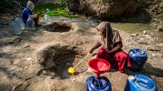 Sejumlah warga mengambil air dari belik yang dibuat di dasar sungai yang mengering di Dusun Ngedat, Desa Ketro, Grobogan, Jawa Tengah, Kamis (13/8/2026). [ANTARA FOTO/Aprillio Akbar/kye]